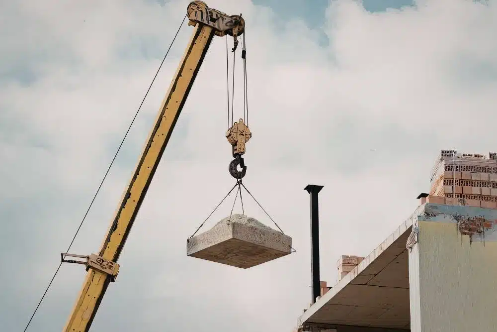 Mobile crane lifting a concrete slab on a construction site — c0 crane ticket guidance for crane operators.