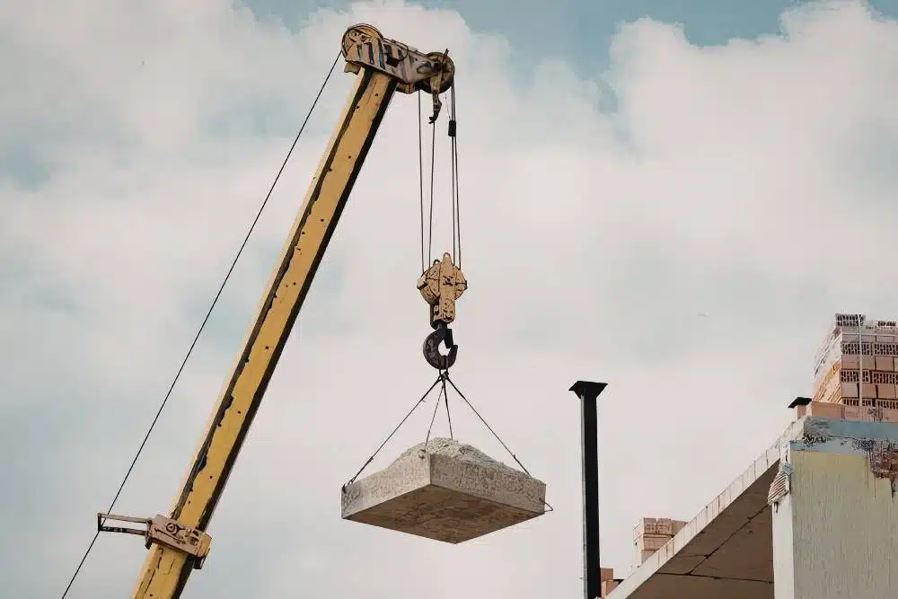 Crane lifting a concrete slab on a construction site during practical dogging and lifting work for a government-funded dogman course.